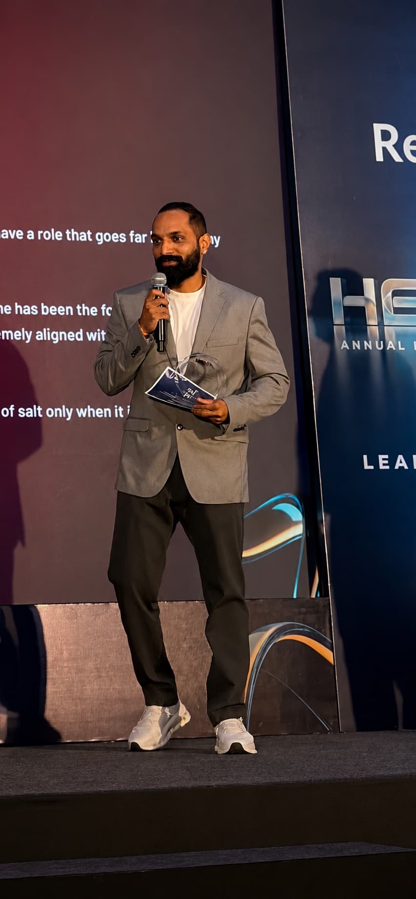 Rupesh S. Ghadi speaking on stage at an industry event